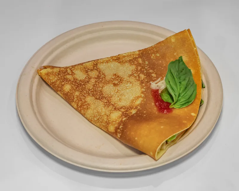 Sweet crepes with strawberries and syrup